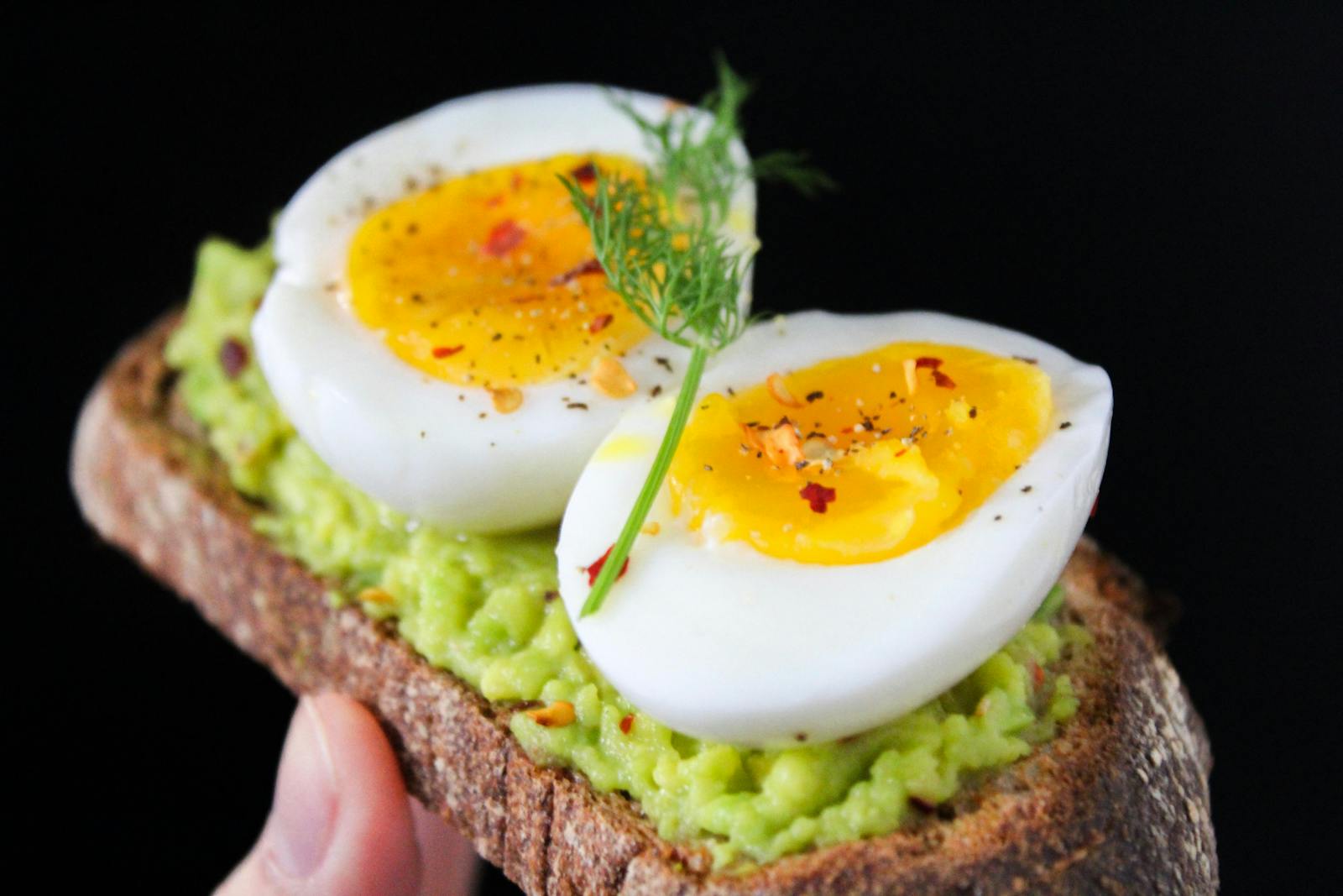 A delicious and healthy avocado toast topped with soft-boiled eggs, perfect for a nutritious breakfast.